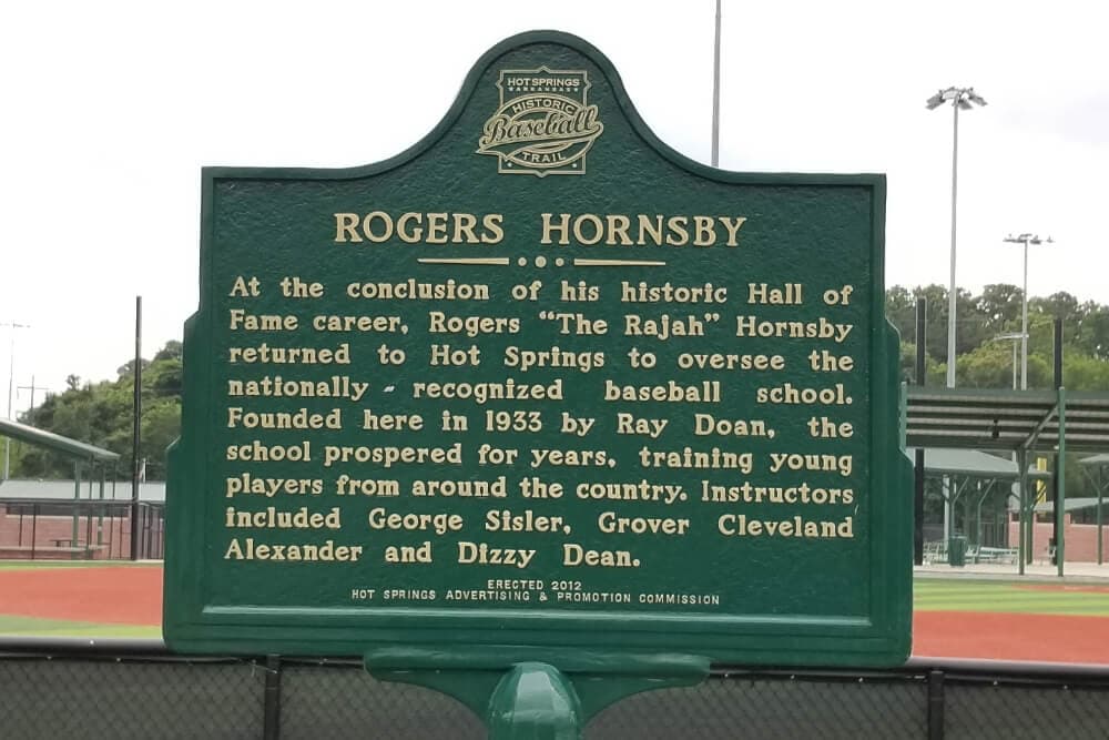 A green sign that says Rogers Hornsby with a history of his baseball career.